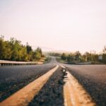 gray asphalt road in between trees