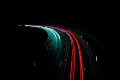 a long exposure photo of a highway at night