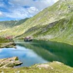 green mountains beside lake under blue sky during daytime